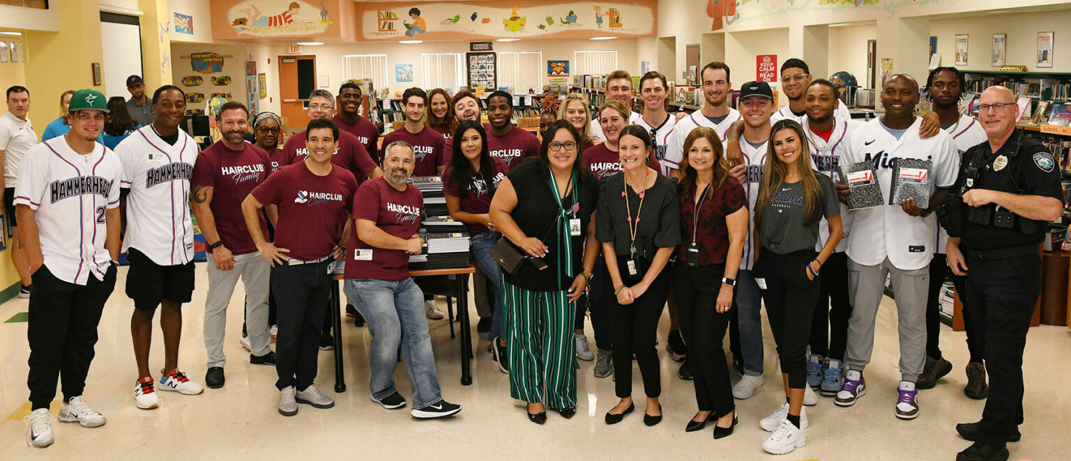 Marlins Back to School Event - teachers, HairClub staff, and Miami Marlins baseball players posing for a photo at a Back to School charity event.