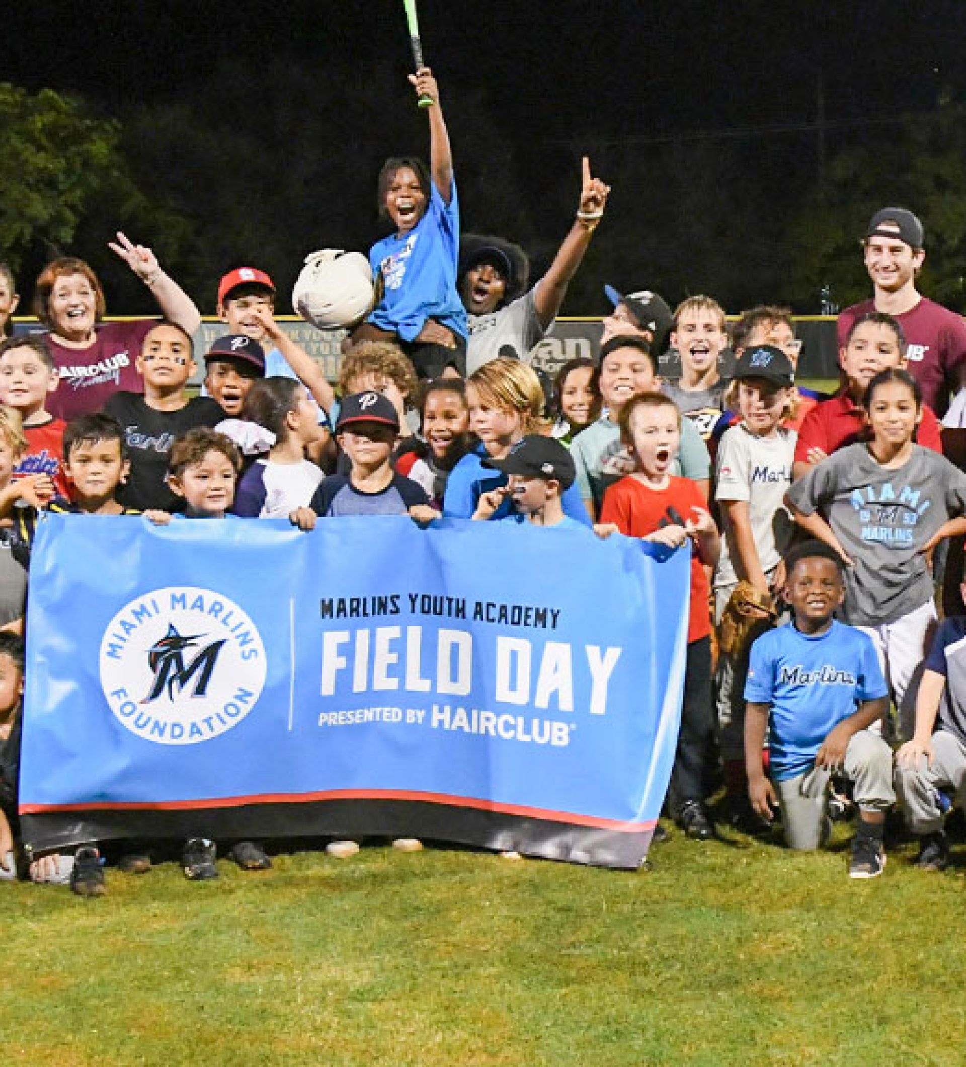 Group image of kids and volunteers on a baseball field