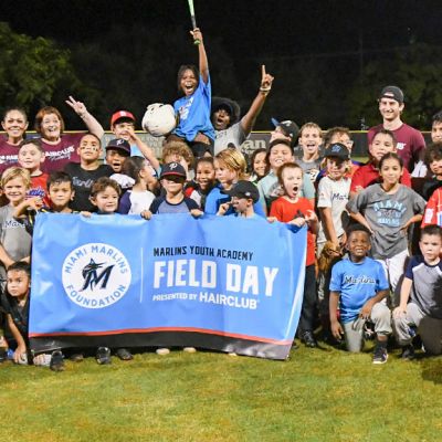 Group image of kids and volunteers on a baseball field