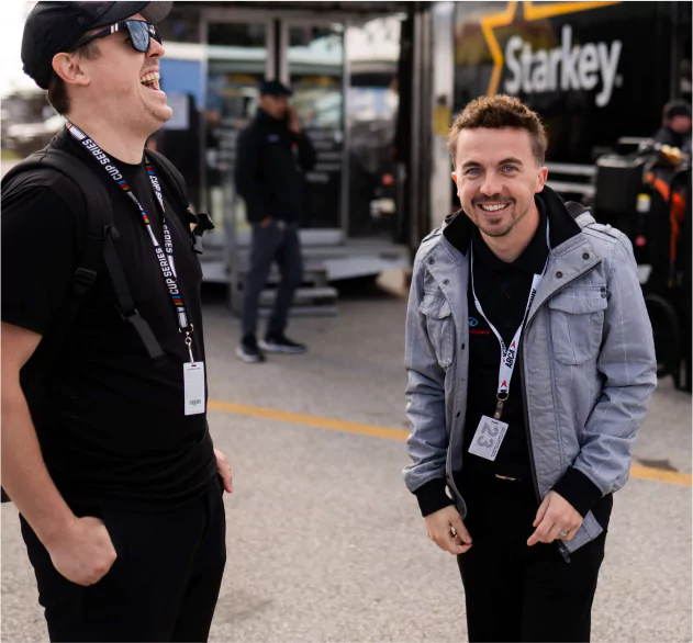 Celebrity Frankie Muniz - laughing while sharing a funny moment with another guy.