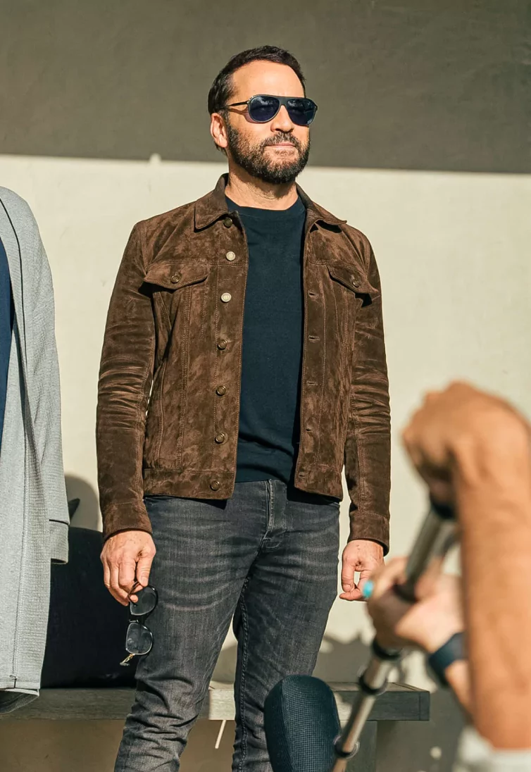 Celebrity Jeremy Piven - in a black t-shirt, a lightweight brown jacket - he is outside and wearing sunglasses.